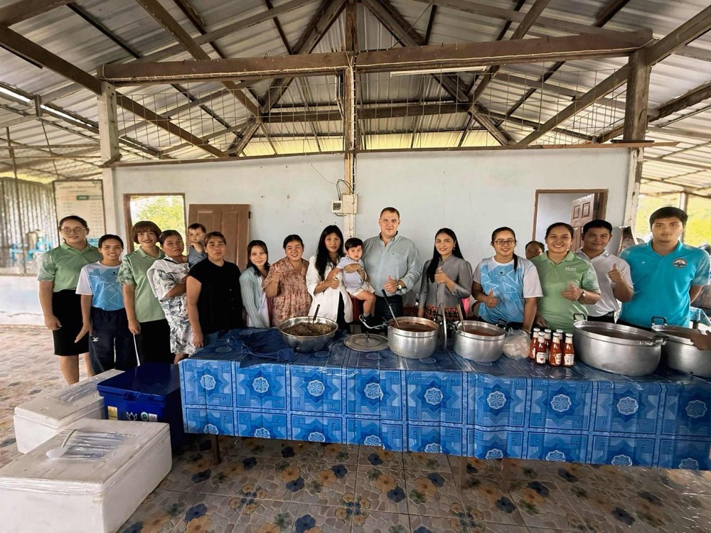 Benjamin Cunningham with a large group at a community meal preparation event in Thailand